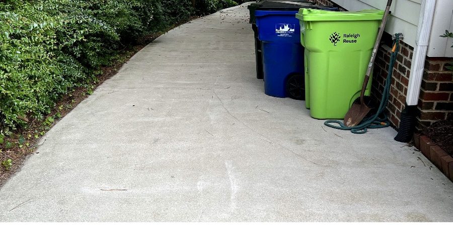 Driveway covered in yellow algae and stains before pressure washing Cary NC